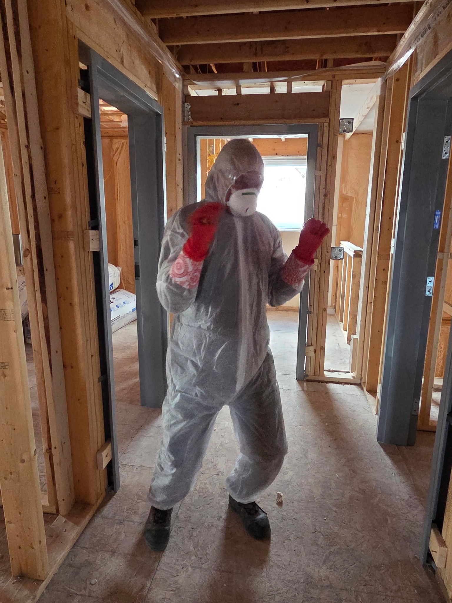Professionnel équipé pour l'application d'isolant en mousse dans une charpente en bois