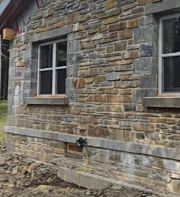 Mur extérieur en pierre naturelle construit autour de fenêtres