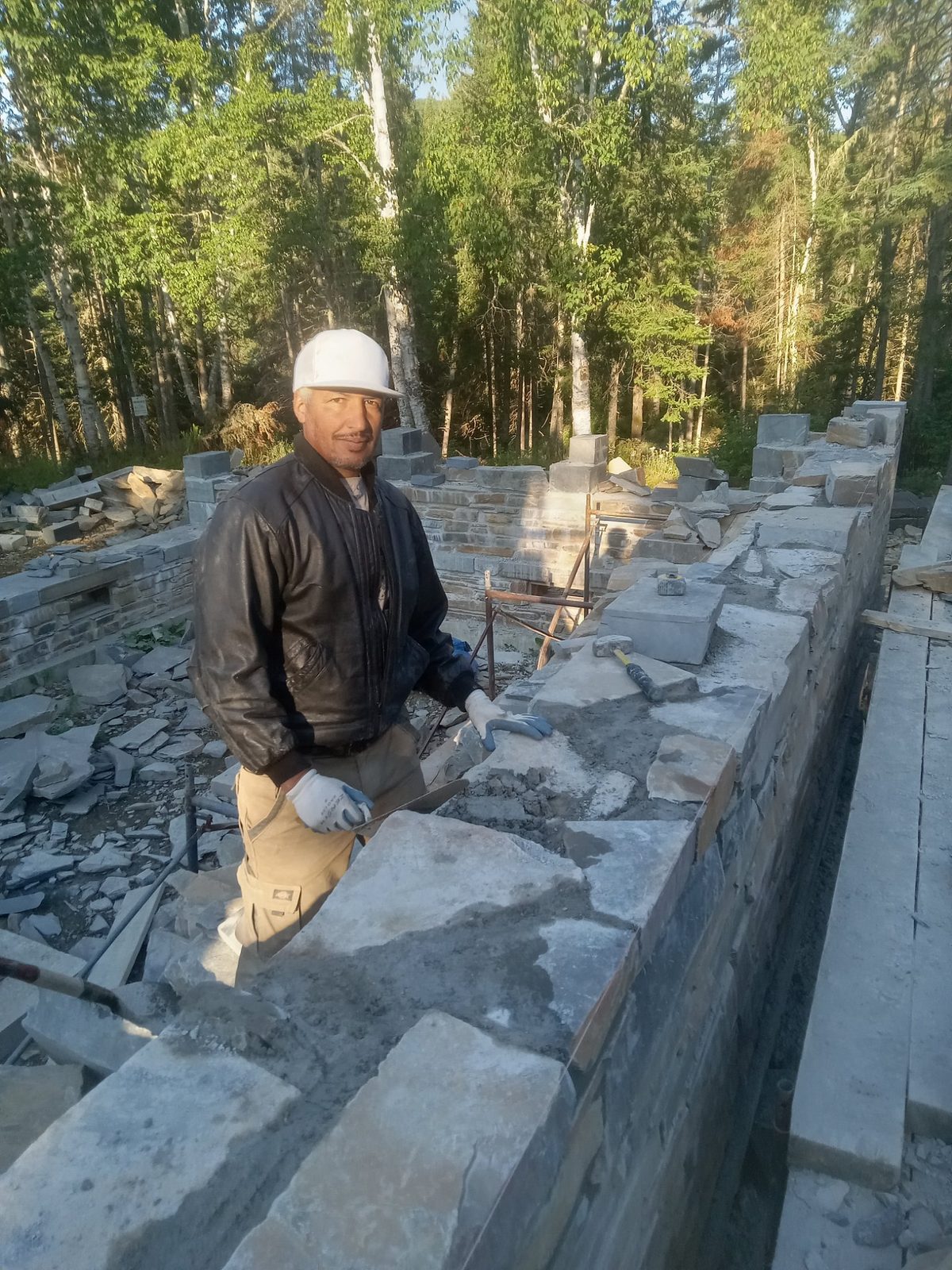 Maçon construisant un mur en pierre naturelle